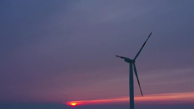 Silhouette of energy producing wind turbines at sunset, Poland