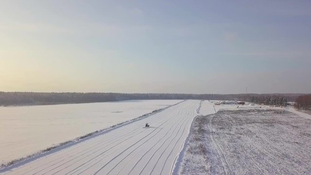 Aerial view of a tractor removing snow from a takeoff runway