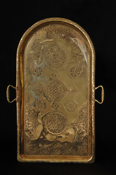 ancient oriental metal tray on dark background. antique bronze tableware