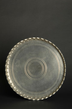 ancient oriental metal tray on dark background. antique bronze tableware