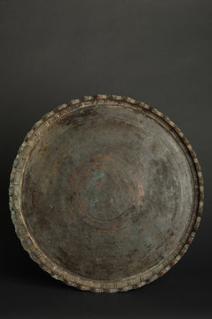 ancient oriental metal tray on dark background. antique bronze tableware