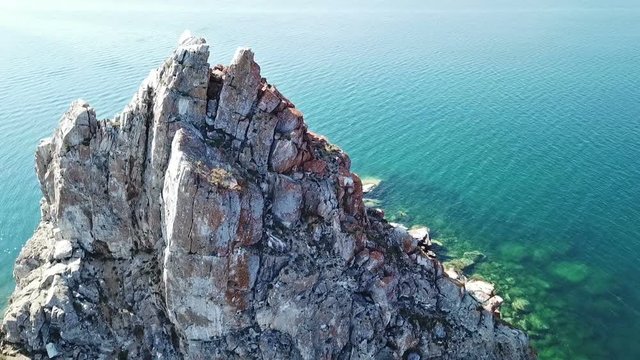 Tranquil Aerial View of the Baikal Bay Shamanka. White ship in calm bay at great lake. Olkhon Island, Baikal. Drone footage.