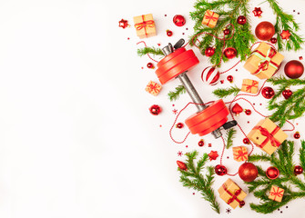 Christmas or New Year on a white background. Composition with dumbbells, gift, red and gold glass balls, fir tree branches for healthy lifestyle and sport