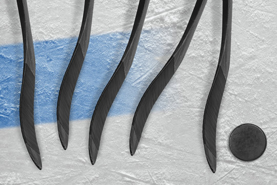 Five of hockey sticks, puck and blue stripe