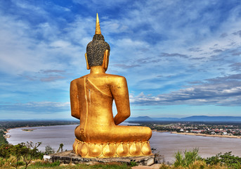 Meditating Gautama buddha sculpture overlooking Mekong river