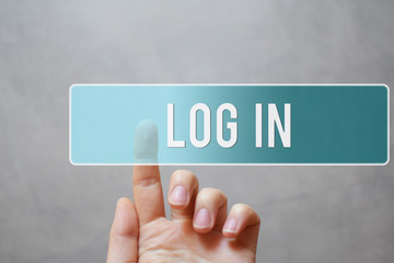 Log in - finger pressing blue transparent button on virtual touchscreen interface on gray background with copy space for text. Internet networking and social media concept.