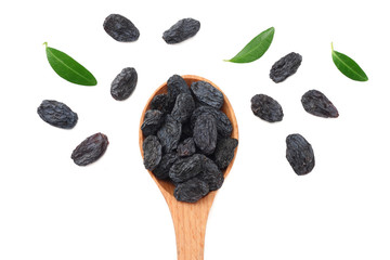 black raisins in wooden spoon with green leaves isolated on white background. top view