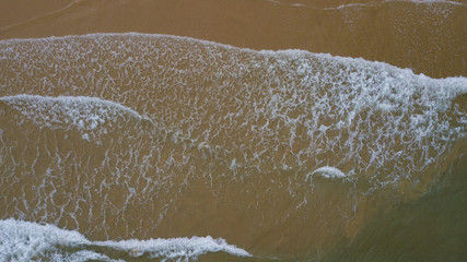 Aerial view beautiful of sea waves, sand from drone. Stock image ocean water, sea surface, sand. Top view on turquoise waves, clear water surface texture. Top view, amazing nature beach background