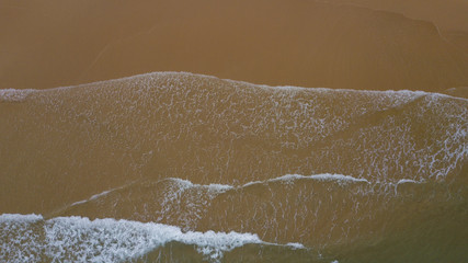 Aerial view beautiful of sea waves, sand from drone. Stock image ocean water, sea surface, sand. Top view on turquoise waves, clear water surface texture. Top view, amazing nature beach background