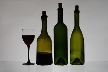 Half empty bottles and a glass of wine