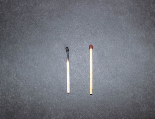 Two household matches on a black background.