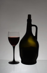 A glass of red wine and a bottle
