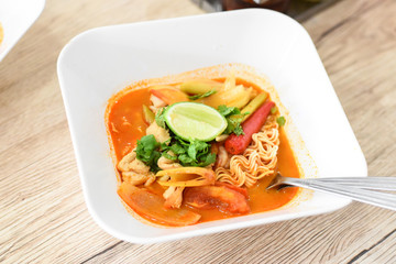 Hot Tom Yum Noodles on Vintage Wooden Background