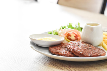 Beef steak, salad and french fries on a vintage wood background