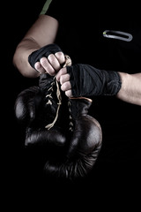  pair of very old boxing sports gloves in men's hands