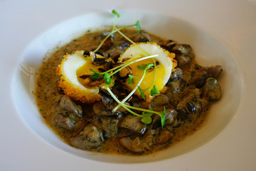 Twice cooked eggs poached and deep fried on top of mushroom ragout