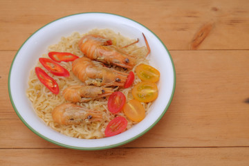 Hot and spicy instant noodle with prawn isolated on the wooden background