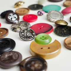 Lot Of Colorful Buttons on White Wooden Table