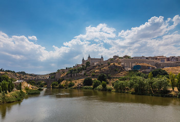Fototapeta premium View of the old city and the Alcantara Bridge leading to the Gate of the Sun from the side of the River Tajo Toledo, Spain.
