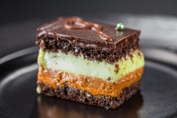 Close-up chocolate biscuit cake with pistachio cream and boiled condensed milk