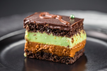 Close-up chocolate biscuit cake with pistachio cream and boiled condensed milk