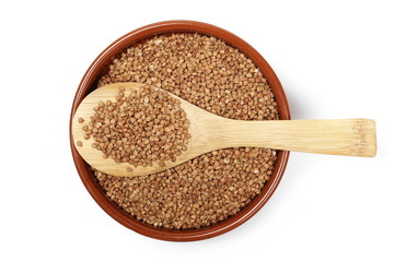 Buckwheat in bowl with wooden spoon isolated on white background, top view