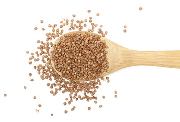 Buckwheat with wooden spoon isolated on white background, top view