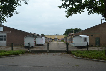 bedrijfspand met hekwerk en bouwketen op een industrieterrein