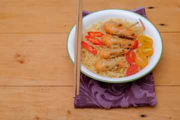 Hot and spicy instant noodle with prawn isolated on the wooden background