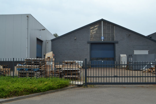 bedrijfspand met oprit, hek en kanteldeur  met pallets