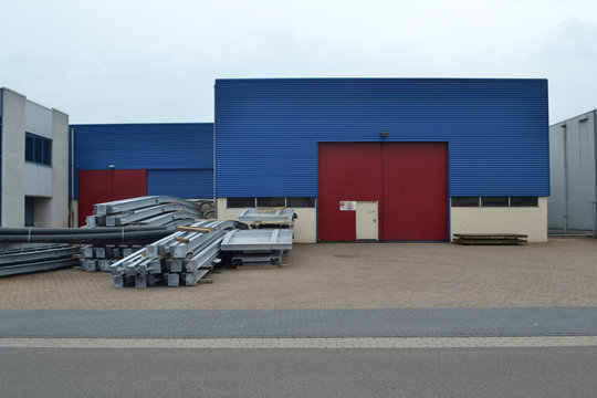 bedrijfspand op een industrieterrein met oprit en kanteldeur en stalen balken aan een straat 