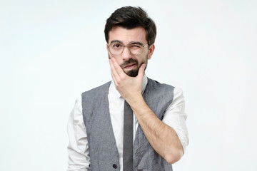 Doubtful bearded young spanish man looking with mistrust. Negative human emotion