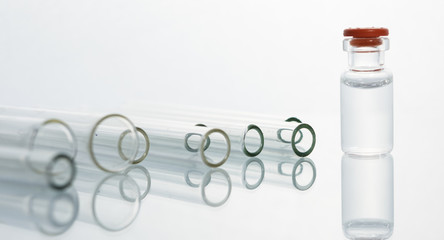 Group of vials with medication on blue methacrylate table.