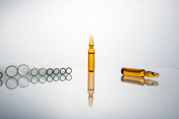 Group of vials with medication on blue methacrylate table.