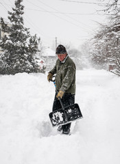 Man with a shovel cleans the track from the snow