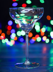 What to drink on christmas party. Alcohol cocktail for winter party. Cocktail ideas concept. Easy recipes for winter alcoholic cocktail drinks. Cocktail glass on defocused garland colorful lights