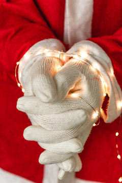 Gefesselte H&auml;nde eines Weihnachtsmannes mit Lichtern