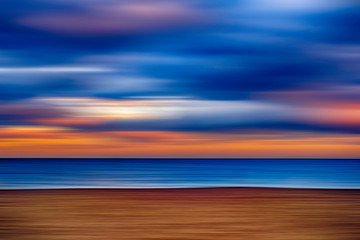 Obraz premium Cloudy sunset on the beach, motion blur