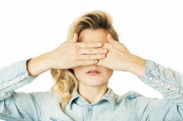 Beautiful young emotional girl closes her eyes to an isolated white background. Do not want to see