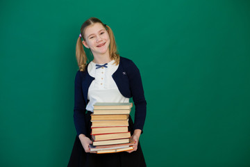 schoolgirl girl during a lesson at the Blackboard with books