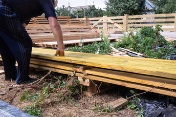 Worker puts the boards on the construction site.