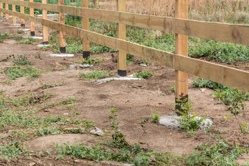 The base of the wooden fence. Fence ranch style details.