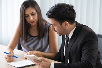 Serious busy young business colleagues discussing agenda. Thoughtful modern business team sitting at table and analyzing information. Teamwork