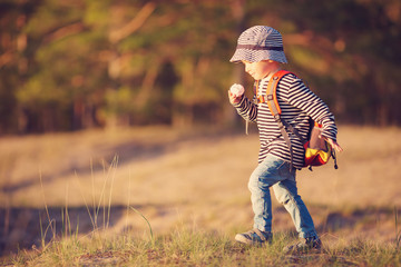 boy going camping with backpack in nature