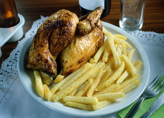 Plato combinado con medio pollo a la barbacoa y patatas fritas.