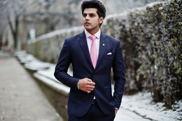 Elegant indian macho man model on suit and pink tie posed on winter day.