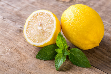 Yellow lemon with mint on wooden table