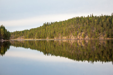 Summer landscape on the lake in Finland. Beautiful view of the lake and the forest on the rocks