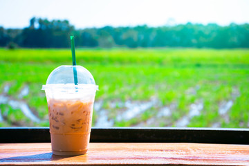 Coffee on green field background, Ice coffee on green field with sunrise in the morning, Light yellow sun shine with green garden, landscape nature background, Nature background, Quiet place relaxing