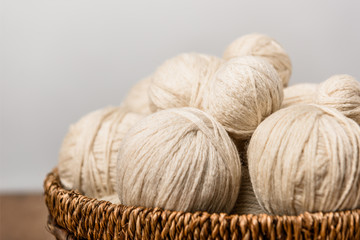 Fototapeta na wymiar close up view of yarn balls in wicker basket on grey background